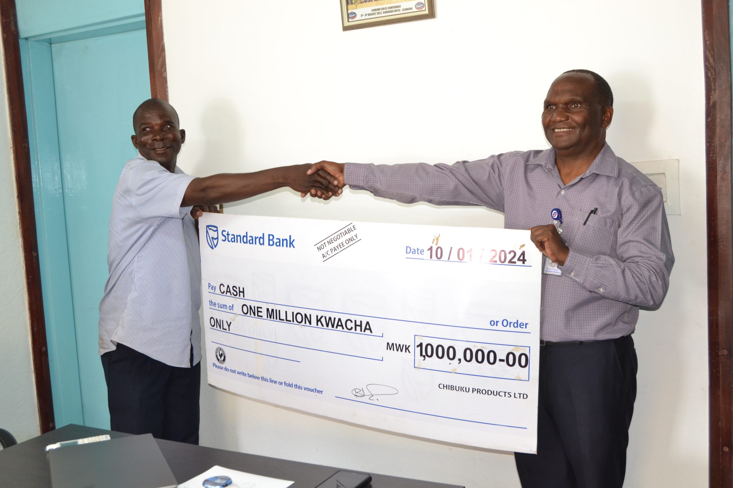 Chunga (right) presenting a dummy cheque to Mbewe at the Lilongwe Brewery on 11 January 2024--Photo by Watipaso Mzungu