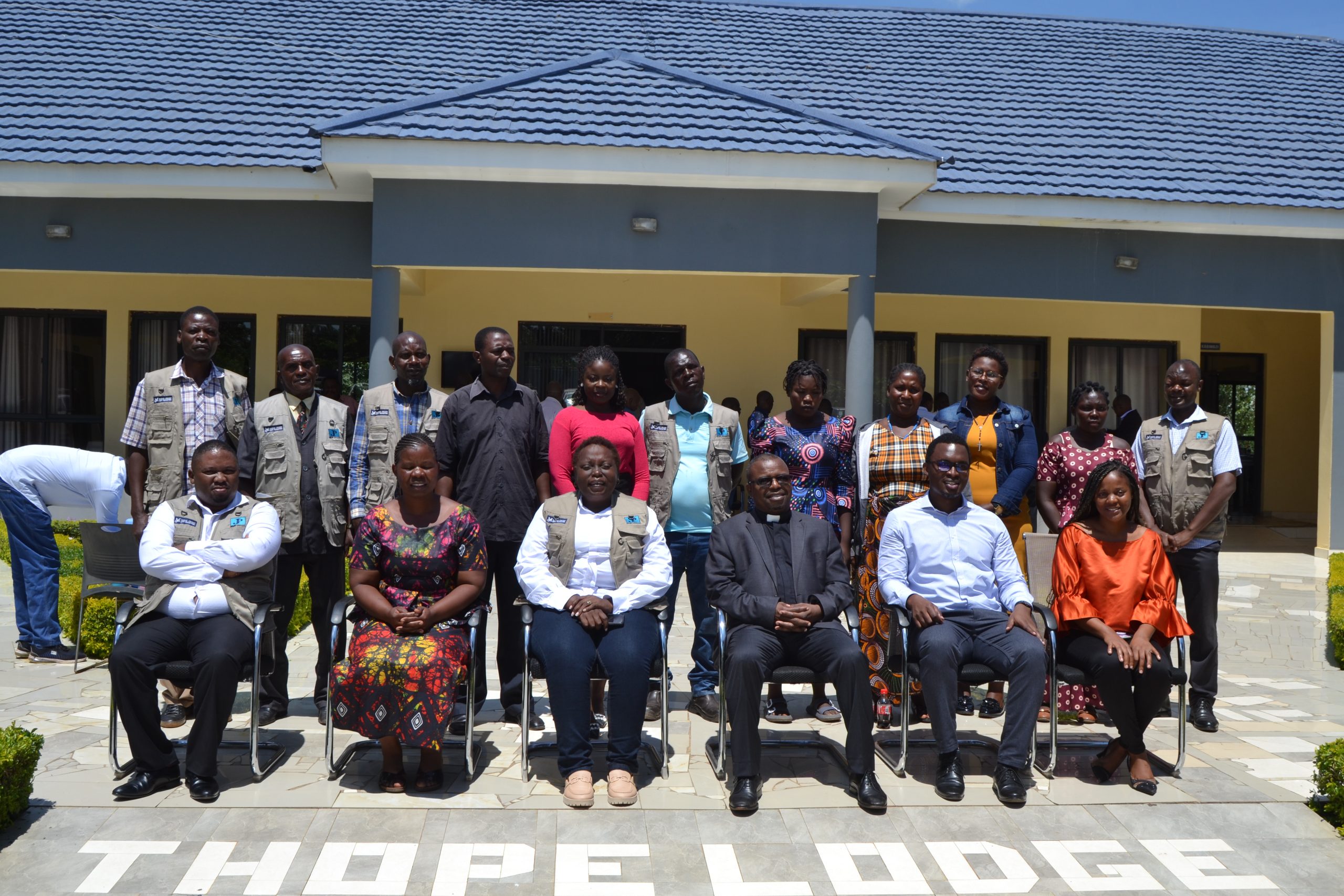 Father Kubalasa sitting 3rd from right posing for a photo with CCJP officials and participants to the workshop Photo by Watipaso Mzungu scaled