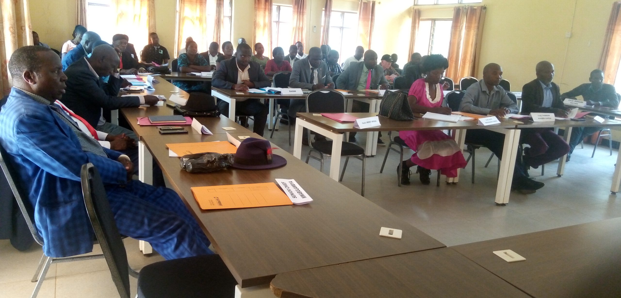 Members of district council listening to Councillor Lwanja scaled