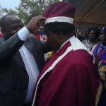 The minister helps one the chiefs putting on a crown