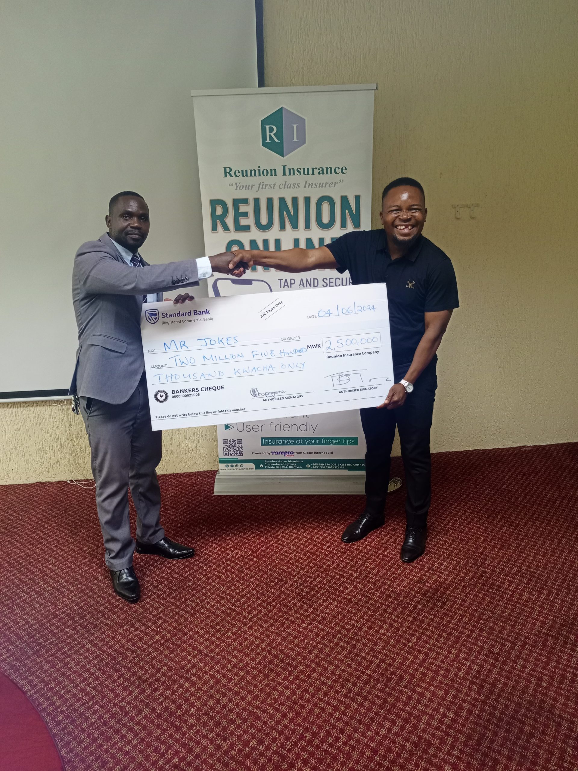 Mr. Jokes (right) receiving a dummy cheque from Mr. Miller John Joshua of Reunion Insurance Company of Malawi