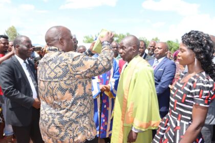 Minister Chimwendo Banda dresses up the newly installed chief a ceremonial hat
