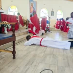 Deacon Chipeta (lying down) awaits to be ordained