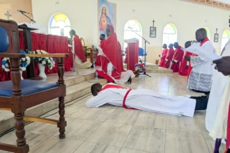 Deacon Chipeta (lying down) awaits to be ordained